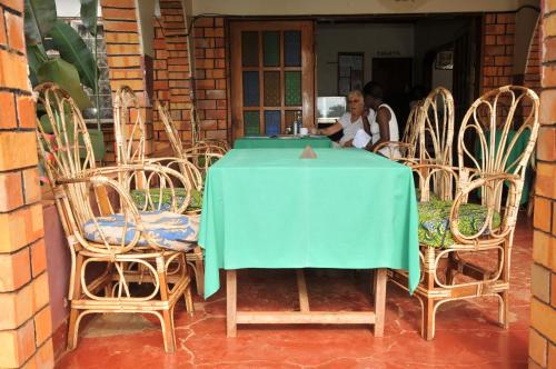 MasindiNew Court View Hotel的坐在桌子上,带两把椅子的女人