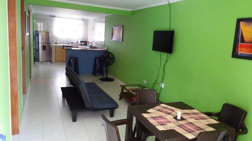 圣安德烈斯Miss Leila的一间拥有绿色墙壁和桌椅的用餐室