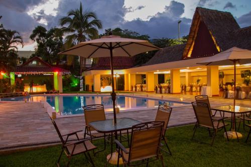 圣萨尔瓦多贝斯特韦斯特普拉斯特拉扎酒店的游泳池旁配有桌椅和遮阳伞