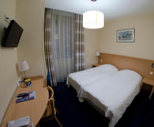 安锡诺德酒店的酒店客房设有一张床、一张书桌和一台电视机。
