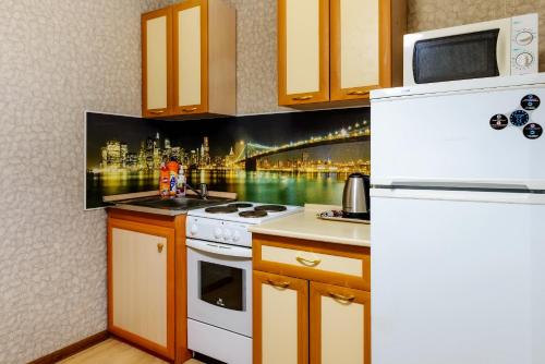 沃尔库塔Apartment TwoPillows on Lomonosova 9的厨房配有白色炉灶和冰箱。