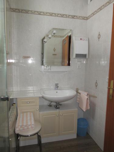 拉肯霍夫Haus Margarete的一间带水槽、镜子和凳子的浴室