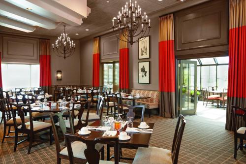 丹伯里伊桑艾伦酒店的用餐室配有桌椅和吊灯。