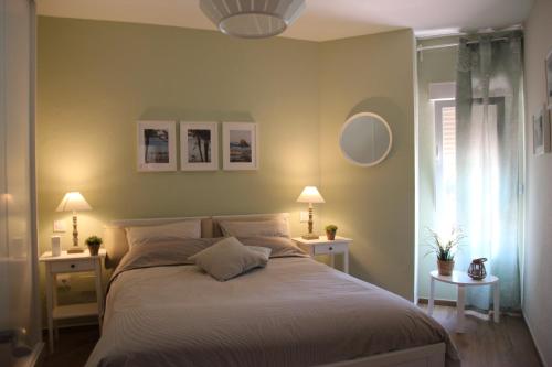 阿尔姆尼卡Bella vida en Almunecar的一间卧室配有一张大床、两张桌子和两盏灯。