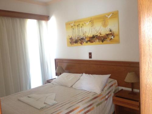 邦比尼亚斯Raio do Sol Residence的一间卧室配有一张带两条白色毛巾的床