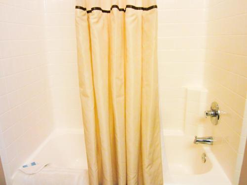 圣罗伯贝尔长住及套房酒店的带浴缸和浴帘的浴室