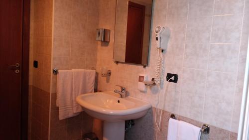卡斯特罗维拉里Hotel La Falconara的一间带水槽的浴室和墙上的一部电话