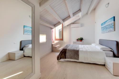 威尼斯丽都拉方丹公寓式酒店的白色卧室配有床和镜子