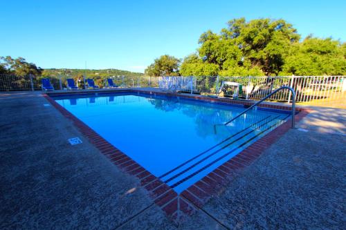 Lago VistaThe Shores at Lake Travis, a VRI resort的蓝色海水游泳池和围栏