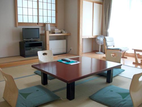 松本上高地西伊豆山日式旅馆的客厅配有木桌和椅子