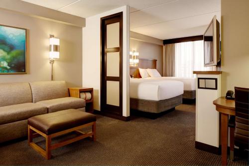艾迪生凯悦达拉斯北酒店的酒店客房,配有床和沙发
