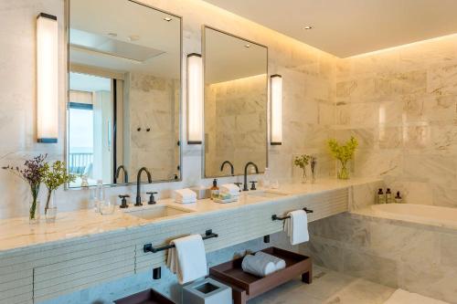 里约热内卢君悦里约热内卢酒店的浴室设有2个水槽、浴缸和镜子