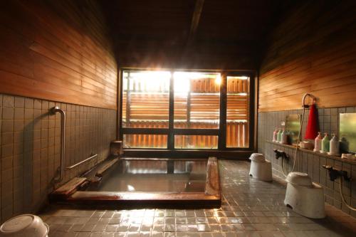 藏王温泉勒韦尔酒店的带浴缸的浴室和窗户