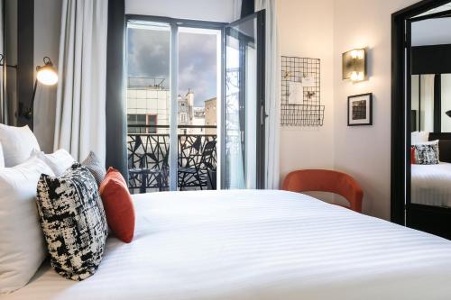 巴黎巴黎城市拉萨Spa酒店的卧室配有一张大白色床和窗户