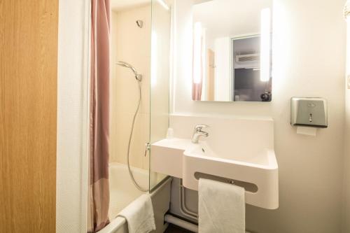 日尔B&B HOTEL Grenoble Université的白色的浴室设有水槽和淋浴。