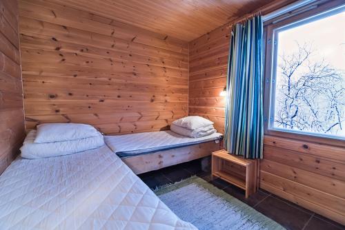 基尔匹斯扎我维Saivaara Cottages的木间设有两张床,设有窗户