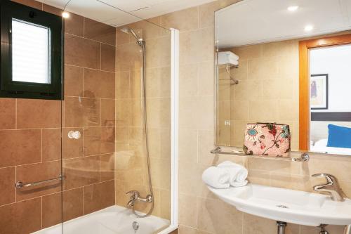 卡门港Hotel Pocillos Playa, solo Adultos的带淋浴、盥洗盆和镜子的浴室