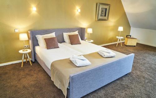 马斯特里赫特Saillant Hotel Maastricht City Centre - Auping Hotel Partner的一间卧室配有一张大床和两条毛巾