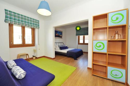 里斯本Cosy Bedrooms Guest House的客厅配有蓝色的沙发和床。