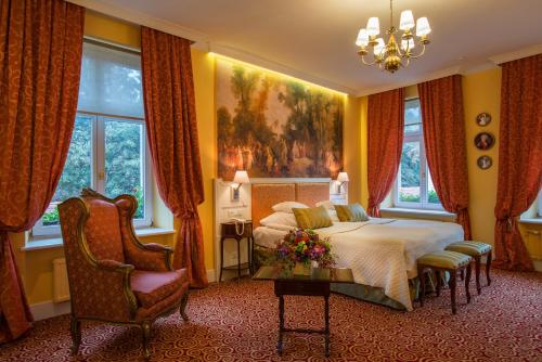 克拉科夫波尔斯基比亚莱姆奥尔莱姆酒店的卧室配有一张床,墙上挂有绘画作品