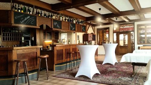 瓦登Locvillare的一间酒吧,在一间房间里设有两个白色凳子