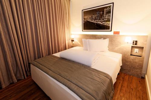 圣保罗Ramada Encore Sao Paulo Tiradentes Centro的酒店客房设有床和窗户。