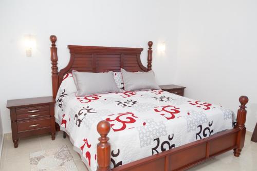 SabanetaGran Hotel Marien的一间卧室配有一张床,床罩上标有美元标志