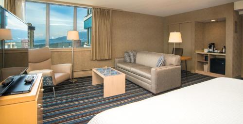 温哥华蓝色地平线酒店的酒店客房,配有床、沙发和椅子