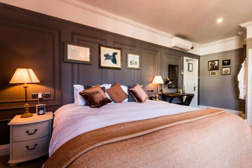 伦敦酿酒者旅馆的一间卧室配有一张大床和两盏灯。