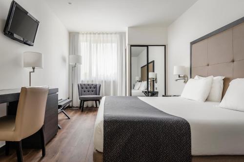 塞丹约拉·德尔·瓦勒欧洲之星瓦莱斯公园酒店的配有一张床和一张书桌的酒店客房