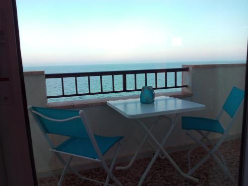 皮拉尔－德拉奥拉达达PLAYA 1 - PRIMERA PRIMERA LINEA DE PLAYA的海景阳台上的桌椅