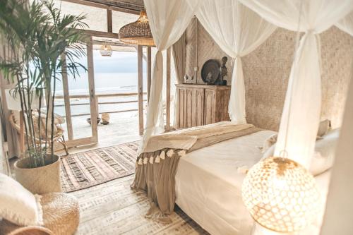 乌鲁瓦图德雷姆西巴厘度假村的一间卧室设有一张天蓬床,享有海景