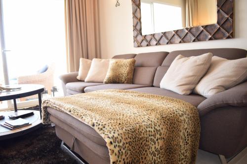 马贝拉La Concha Vista La Quinta的客厅配有长沙发,上面有豹子毯子