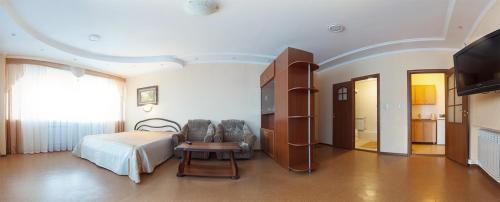 鄂木斯克Hotel Na Svetlom的一间卧室配有一张床、一张桌子和一台电视。