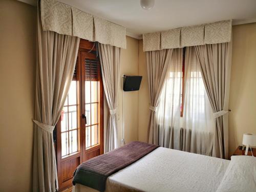阿维拉阿尔坎塔拉旅舍的一间卧室配有床和带窗帘的窗户