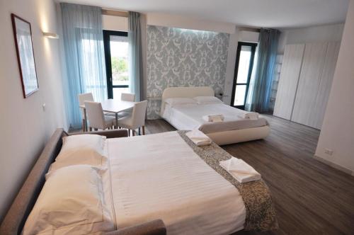 马里纳迪蒙泰马尔恰诺Eden Park的酒店客房带两张床和一张桌子以及椅子。