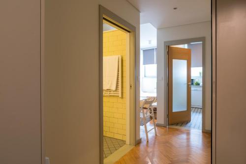 波尔图三一公寓酒店的走廊上设有镜子和黄色的墙壁