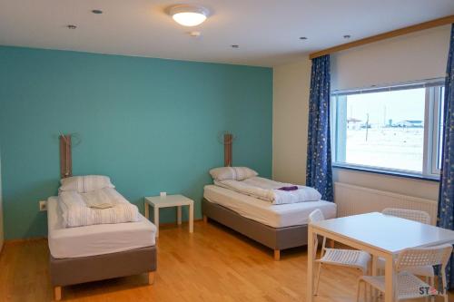 凯夫拉维克凯夫拉维克机场旅舍的客房设有两张床、一张桌子和一扇窗户。