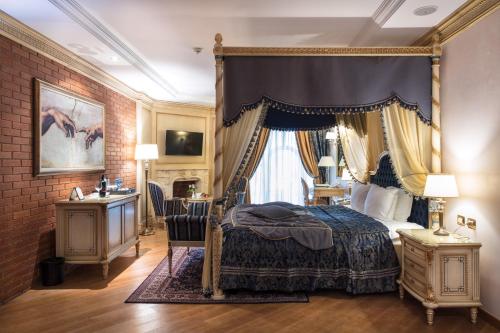 地拉那Xheko Imperial Luxury Hotel & SPA的一间卧室配有一张天蓬床和一张书桌