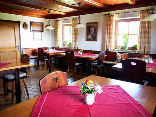 诺伊舍瑙Pension Draxlerhof的餐厅配有桌椅和红色桌布
