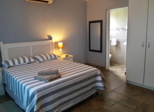 赫卢赫卢韦Umsinsi Cottage的一间带大床的卧室和一间浴室