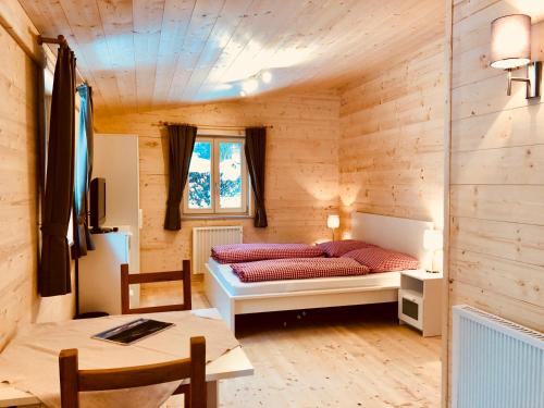 瓦尔赫湖Mountain Inn Chalets & Apartments的木制客房内的一间卧室,配有一张床