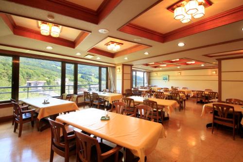 藏王温泉藏王广场日式旅馆的用餐室设有桌椅和窗户。