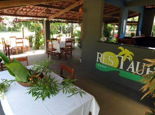 伊塔帕里卡岛维拉克鲁兹Alma Tropical Resort的一间设有桌椅的餐厅,种植了植物