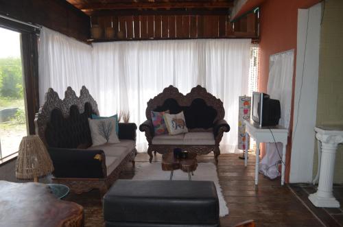 雅克南Pousada Kamaka Praia的客厅配有两把椅子和一张沙发