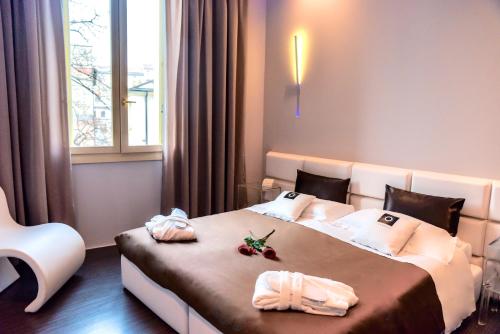 帕多瓦Le Camp Suite & Spa的一间卧室配有两张带毛巾的床