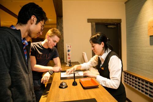 金泽日本金泽胶囊宾馆的一群人站在桌子旁