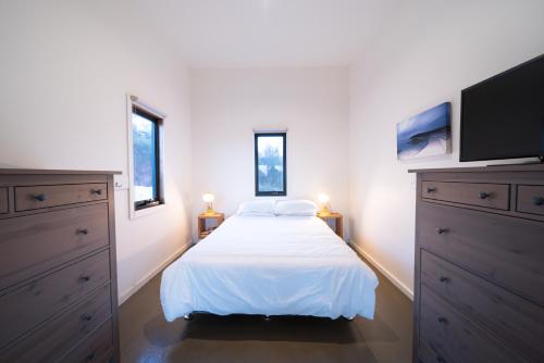 Emita索耶斯湾度假屋的一间卧室配有一张床和一台平面电视