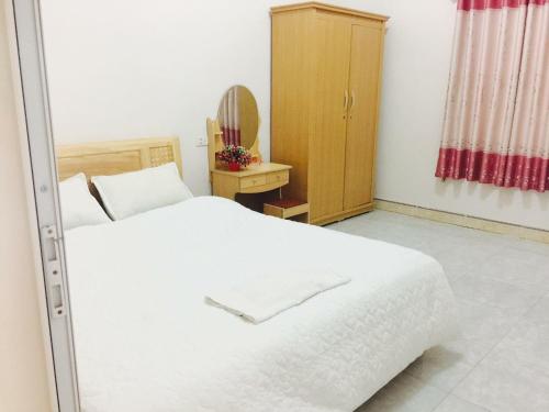 木州县纳尼汉普汽车旅馆的卧室配有白色的床和木制橱柜。