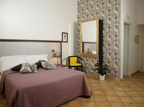那不勒斯卡拉瓦乔酒店的一间卧室配有一张床和一面大镜子